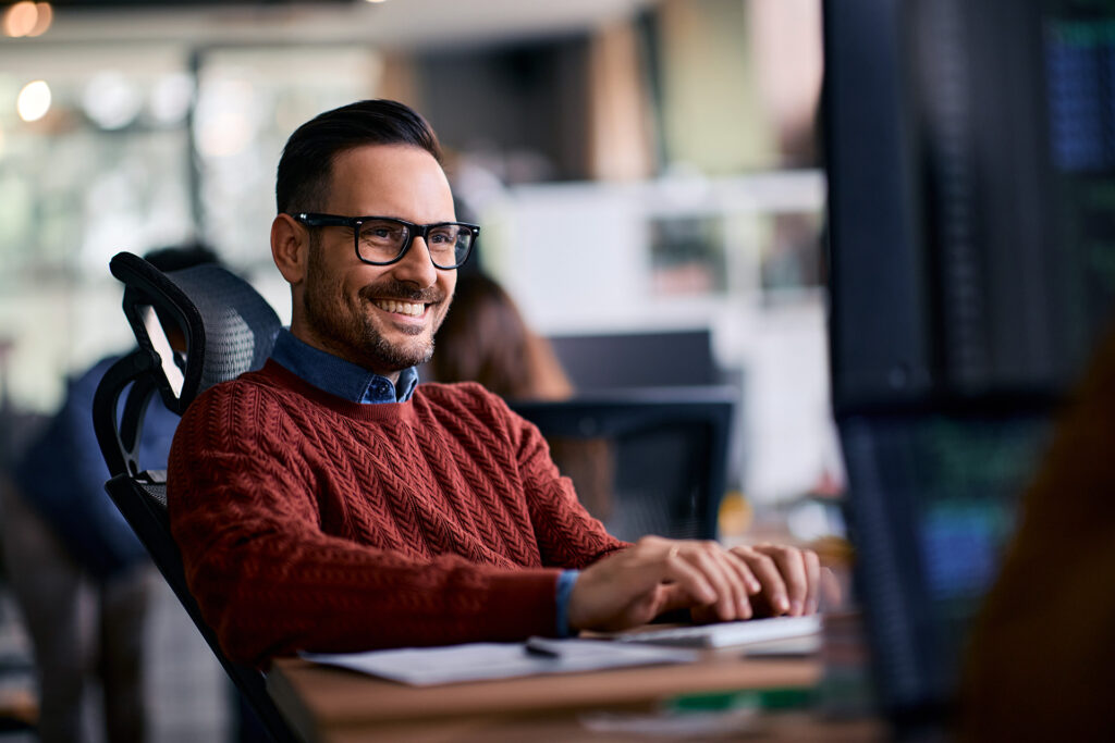 Confident, smiling business man viewing computer at the office.