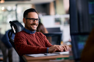 Confident, smiling business man viewing computer at the office.