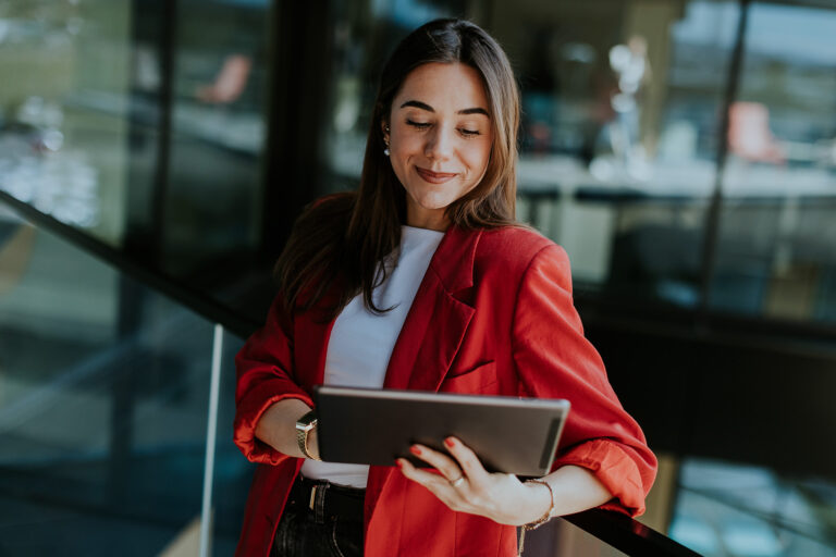 Smiling businesswoman on tablet.