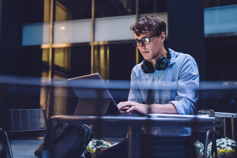 Man with headphones working on laptop.